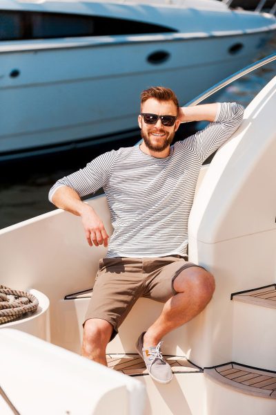 happy-time-his-yacht-cheerful-young-man-holding-hand-head-looking-camera-while-sitting-board-yacht-web